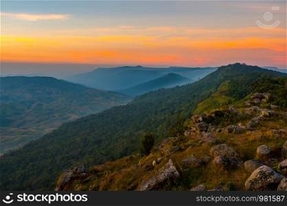 Landscape view poin field rock stone and sunset on hill top mountain orange sky forest background