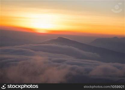 Landscape view point looking for foggy mist cover forest mountain and beautiful sunrise colorful sky yellow background