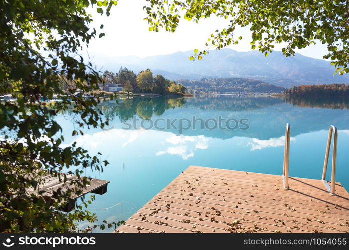 landscape with a beautiful mountain lake and boats in the foreground. autumn