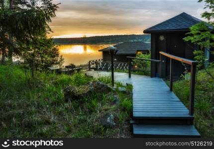 Landscape with a lodge on the lake in Karelia at sunset