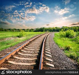 Landscape with a railway among a green field at sunset. Landscape with a railway among a green field
