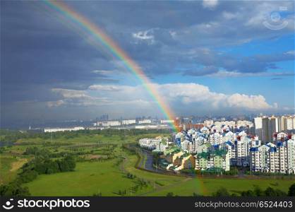 Landscape with a rainbow above city and park. Rainbow of city