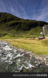 Landscape with a river and cabin on the Norwegian mountain plateau Vikafjellet. Vikafjellet mountain plateau