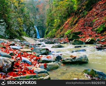 landscape with a waterfall and a mountain river in autumn. landscape with a waterfall and a mountain river in autumn. Autumnal lanscape in mountains