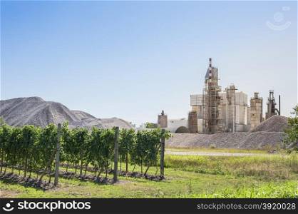 Landscape with cement plant, with vineyards in the foreground