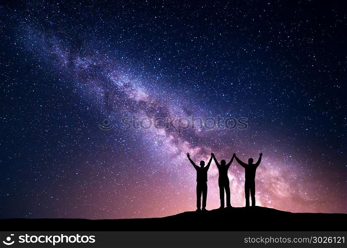 Landscape with colorful Milky Way. Night starry sky with silhouette of a happy family with raised-up arms on the hill. Beautiful Universe. Space background