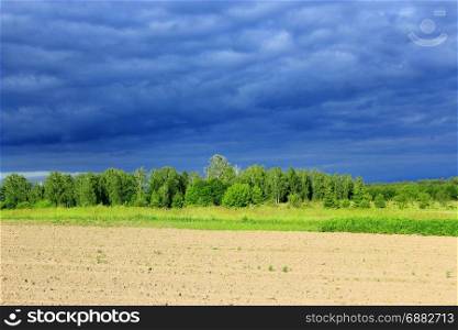 landscape with dark thundercloud sky before rain. landscape with dark thundercloud clouds under the forest and land. The sky before rain