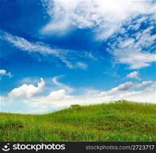 landscape with green grass hill under blue sky