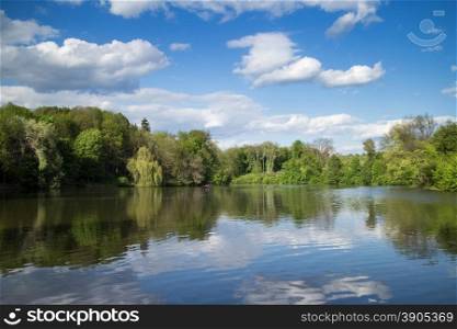 Landscape with lake and green trees under blue sky in park Sofievka, Uman, Ukraine