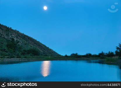 Landscape with moon above the lake. Dark blue night and moonlight reflection in water