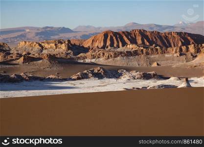 Landscape with mountains as on moon and brown surface of sand dune