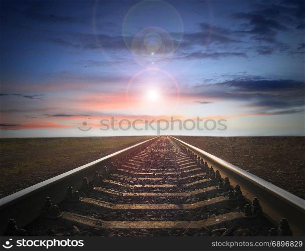 landscape with rails going away to evening sky with sun. landscape with rails going away to evening sky with sun sparkling on the horizon