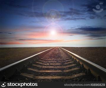 landscape with rails going away to evening sky with sun. landscape with rails going away to evening sky with sun sparkling on the horizon