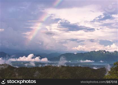 Landscape with rainbows and clouds background.