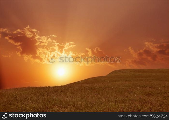Landscape with sun shining through clouds.