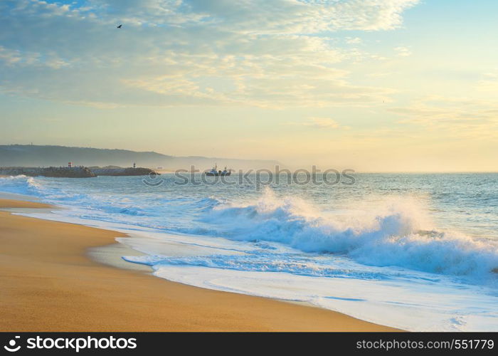 Landscape with the ocean beach, fishing ship at beautiful sunset. Nazare, Portugal