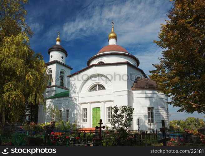 Landscape with white orthodox church and cemetery