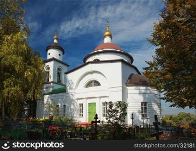 Landscape with white orthodox church and cemetery