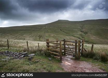 Landscapes. Footpath in Brecon Beacons landscape leading to Corn Du peak with stormy sky overhead