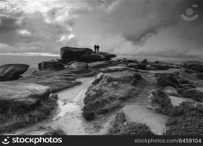 Landscapes. Hikers in black and white Peak District landscape during autumn sunset