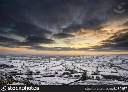 Landscapes. Winter sky over snow covered Winter landscape in Peak District at sunset
