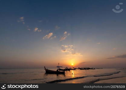 Lanscape of longtail boat in evening time with sunray beam at the beach, Phang Nga, Thailand