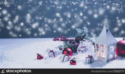 Lantern and red and white christmas decoration on snow and magic lights background. Lantern and christmas decoration