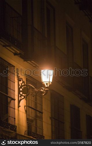 Lantern on a building lit up at night, Madrid, Spain