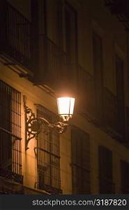 Lantern on a building lit up at night, Madrid, Spain