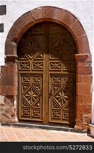 lanzarote spain canarias brass brown knocker in a closed wood church door and white wall abstract