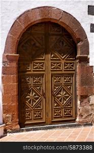 lanzarote spain canarias brass brown knocker in a closed wood church door and white wall abstract &#xA;