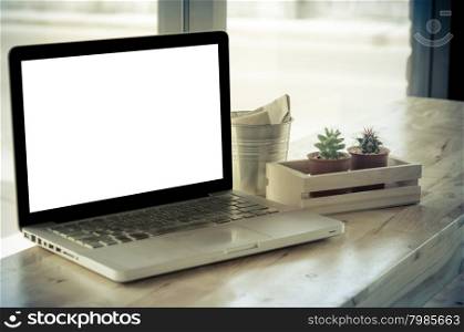 Laptop and cactus in flowerpot on wooden table.Vintage style color effect