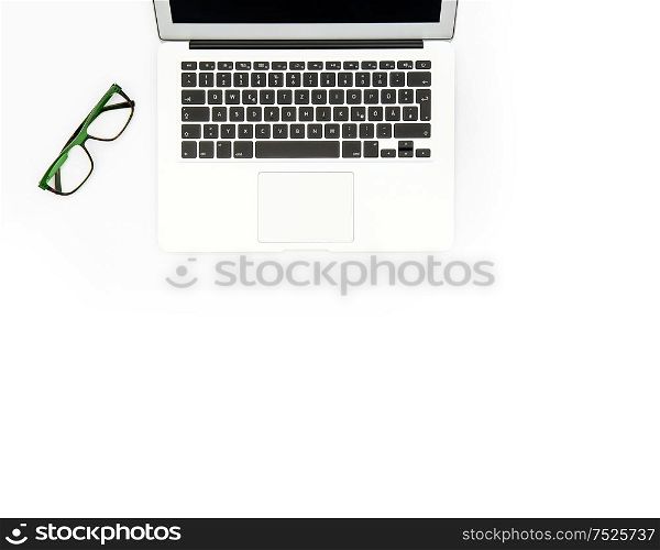 Laptop and glasses on white background. Office workplace. Flat lay mock up