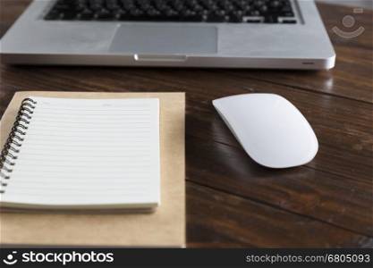laptop computer and notebook on wooden office desk