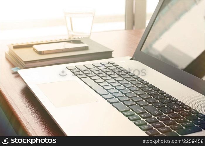 laptop computer is on wooden desk as workplace concept with overcast effect