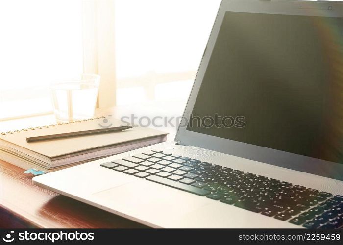 laptop computer is on wooden desk as workplace concept with overcast effect