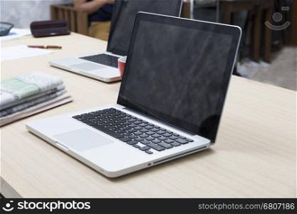 laptop computer, newspaper, document, pen and red coffee cup on wooden table for working concept