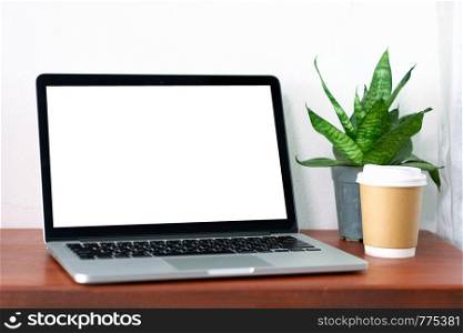 Laptop computer with blank screen and coffee cup on wood table background, mock up display, business and technology, online education, technology lifestyle concept