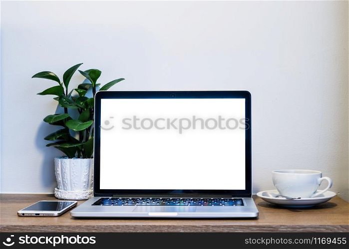 Laptop computer with blank screen with smart phone and a coffee cup on brick wall on wooden table interior of room room hotel background,Work and business in leisure with travel in the holiday concept