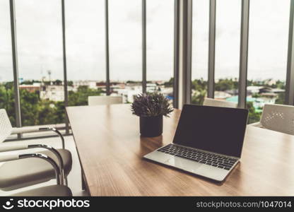 Laptop computer with opened lid on table in office workspace.