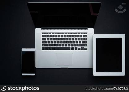Laptop, digital pad and smartphone on black background,top view