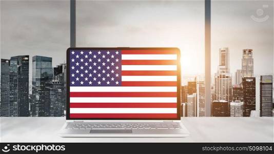 Laptop for USA Independence Day. Independence Day on office laptop screen with panoramic sunset view of modern downtown skyscrapers at business district