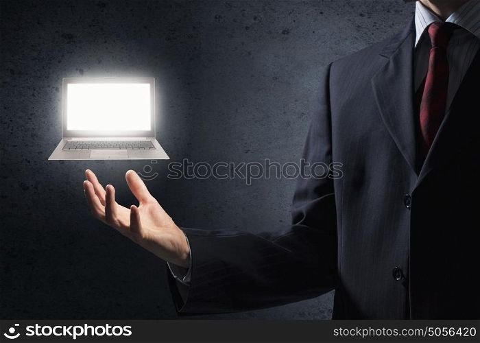 Laptop in hand. Close up of businessman holding laptop in palm
