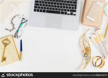 Laptop keyboard with golden woman accessories mock up flat lay styled scene, top view, copy space on white table background. Offise desktop scene