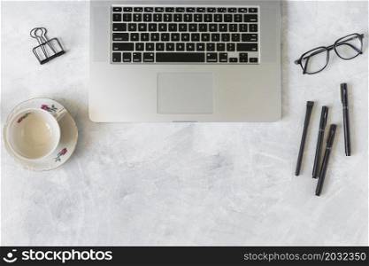 laptop near eyeglasses cup dish