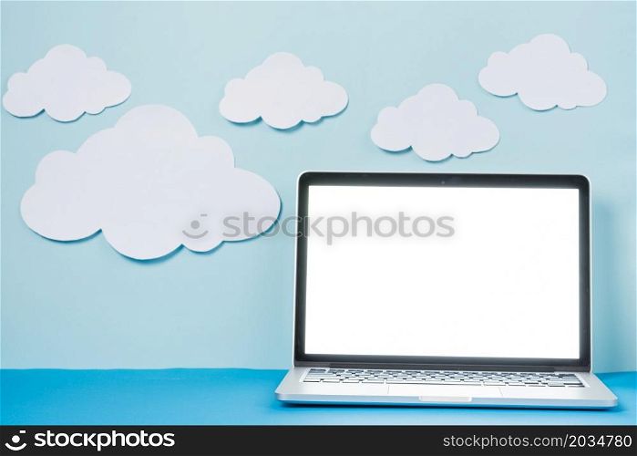 laptop near paper clouds