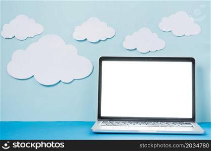 laptop near paper clouds