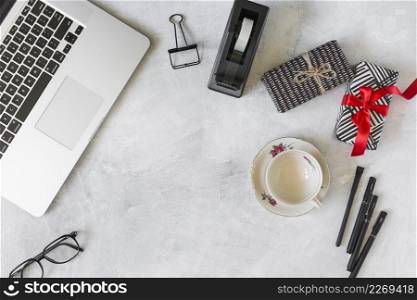 laptop near present boxes cup dish stationery
