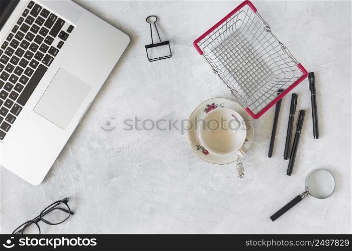laptop near stationery supermarket basket