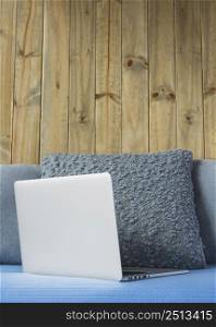 laptop sofa front wooden wall